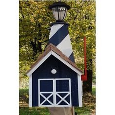 a blue and white birdhouse with a light on top