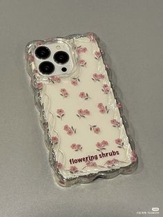 an iphone case with flowers on it sitting on a table