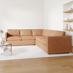 a living room with a couch, coffee table and shelves on the wall behind it