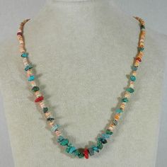 a necklace with multicolored beads on a mannequin