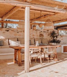 a wooden table sitting under a covered patio