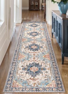 a large area rug in the middle of a hallway with blue vases on either side