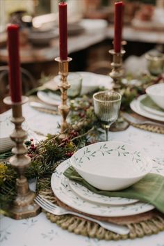 the table is set with plates and place settings