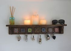 a shelf with candles, keys and sunglasses on it