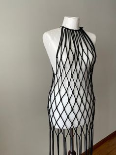 a white mannequin with black netting on it's back and neckline