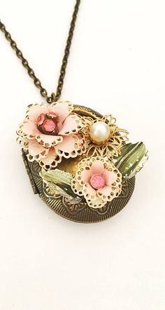 Bronze locket. Rustic flowers and leaves. Pretty to wear Elegant Handmade Antique Gold Locket Necklace, Vintage Gold Flower Necklace For Wedding, Vintage Pendant Necklace With Flower Charm, Vintage Flower Charm Pendant Jewelry, Vintage Jewelry With Flower Charm And Pendant, Vintage Flower Pendant Locket Necklace, Vintage Brass Flower Jewelry, Vintage Brass Jewelry With Flower Charm, Vintage Pink Oval Pendant Jewelry