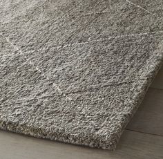 a gray rug on top of a wooden floor with a light colored wood flooring