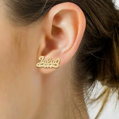 Turn your name into a fashion statement with these enticing stud earrings. Crafted in 14K gold over silver, each personalized earring showcases the name of your choosing - from three to eight characters in length - sculpted in a hammered script font. Beneath the name, a similarly textured heart and scroll ribbons complete the look. Buffed to a brilliant luster, these post earrings secure comfortably with friction backs. Personalized Drop Earrings For Anniversary, Custom Name Earrings For Mother's Day Gift, Personalized Yellow Gold Sterling Silver Earrings, Silver Name Earrings For Gift, Custom Name Gold Sterling Silver Earrings, Silver Earrings With Name For Gift, Elegant Personalized Name Earrings, Personalized Nameplate Earrings For Anniversary, Elegant Personalized Earrings