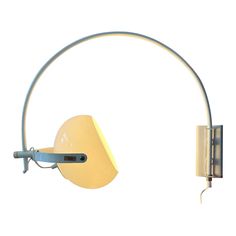 a yellow wall mounted light with a metal arm and white back ground, against a white background