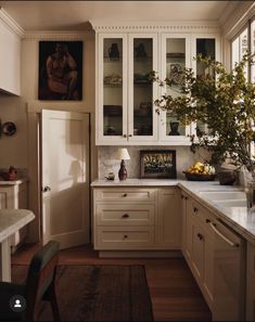 a kitchen filled with lots of white cupboards and counter top space next to a window