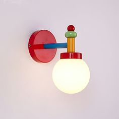 a red wall light with a white ball on the side and a blue pole attached to it