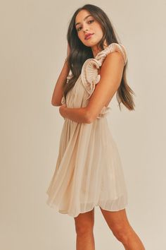 This sleeveless mini dress features a pleated design and a halter neck with a button closure. The open back is highlighted by delicate ruffle detail, and it is lined for comfort. 100% Polyester Sold online only Lined Mini Dress With Ruffled Straps For Date Night, Feminine Mini Dress With Smocked Back, Flowy Sleeveless Ruffle Dress For Date Night, Casual Sleeveless Mini Dress With Smocked Back, Sleeveless Mini Dress With Smocked Back For Casual Wear, Feminine Flowy Lined Mini Dress, Feminine Dress With Smocked Back For Date Night, Elegant Sleeveless Mini Dress With Gathered Neckline, Brunch Mini Dress With Pleated Bodice