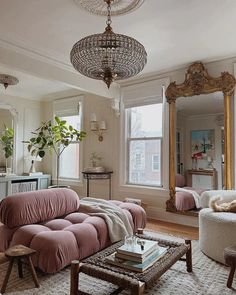 a living room filled with furniture and a chandelier hanging over the top of it