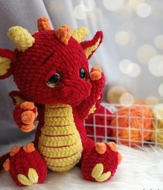 a crocheted red and yellow dragon stuffed animal