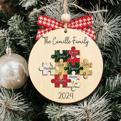 a christmas ornament hanging on a tree with a puzzle piece in the middle