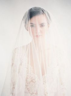 a woman wearing a wedding veil and posing for the camera