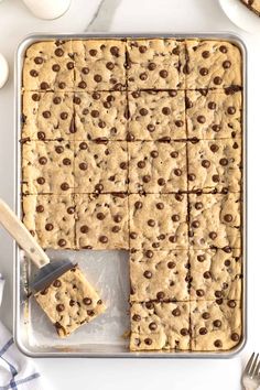 chocolate chip cookie bars cut into squares and placed on a baking sheet with a spatula