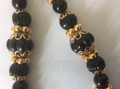 "Trifari TM necklace, made in 1990-s. Black plastic melon beads, round beads, gold beads, gold bead caps necklace Necklace: 30\" Excellent vintage condition." Festive Gold Beaded Necklaces With Black Beads, Elegant Black Beads With Gold Details, Elegant Gold Beads With Black Details, Gold Necklaces With Black Beads For Festivals, Black Jewelry With Gold Beads For Formal Occasions, Formal Black Jewelry With Gold Beads, Black Beaded Necklaces With Large Beads For Festivals, Black Beaded Necklace With Large Beads For Festivals, Elegant Black Beaded Necklaces For Festivals