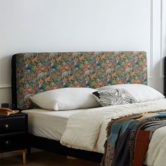 a bed with an upholstered headboard and pillows on top of it in a bedroom