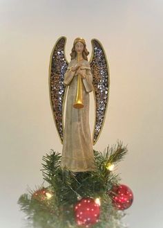 an angel figurine on top of a christmas tree