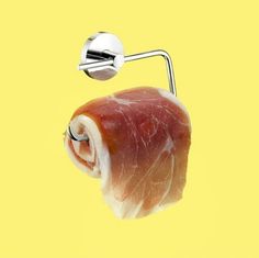 a piece of meat hanging from the side of a wall mounted toilet paper dispenser