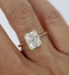 a woman's hand with a ring on it and a diamond in the middle