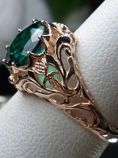 This is a sterling silver filigree ring inspired by Art Nouveau movement of the early 20th century. This beautiful floral filigree ring is set with your choice of a natural or simulated/man-made emerald stone. The natural stone is heat treated for color and clarity. The round full cut emerald is 8mm in diameter. The ring measures 12mm North to South on the finger. The band is marked 925 for sterling silver. Choose rose gold plated or antiqued sterling silver. Elegant Sterling Silver Ring With Rose Design, Classic Rose Gold Emerald Jewelry, Classic Rose Design Jewelry For Anniversary, Elegant Rose Gold Jewelry With Intricate Design, Intricate Rose Gold Sterling Silver Jewelry, Elegant Engraved Emerald Jewelry, Rose Gold Jewelry With Intricate Design For Gift, Oval Rose Design Jewelry For Wedding, Rose Gold Sterling Silver Filigree Jewelry