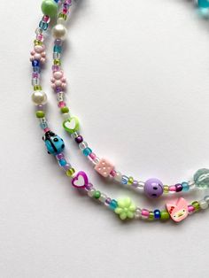 "༺ 🎀 𝓁𝒶𝒻𝒻𝓎 𝓉𝒶𝒻𝒻𝓎 𝓃𝑒𝒸𝓀𝓁𝒶𝒸𝑒 🎀༻ FREE SHIPPING You will receive one necklace like those similar to pictures. Has a pastel blue, pink, green, purple, and white color scheme. Made to order and beaded by me with luvvv <3 Strung on strong cord with a mixture of glass, polymer clay and plastic beads. Some beads you might see on your necklace -- smiley face, butterfly, cute animal, butterfly, gum ball, dice, ladybug, teddy bear, heart, flower, and so much more!! 🍬 Silver lobster cl Mismatched Beaded Necklace, Handmade Fun Beaded Necklaces, Handmade Playful Beaded Necklaces For Jewelry Making, Fun Handmade Beaded Necklaces For Birthday, Adjustable Cute Beaded Necklaces For Festival, Fun Handmade Beaded Necklaces For Birthdays, Cute Purple Beaded Necklace, Cute Handmade Beaded Necklaces With Round Beads, Whimsical Adjustable Beaded Necklaces With Heart Beads