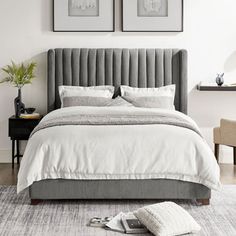 a bedroom with two framed pictures above the bed and an upholstered headboard