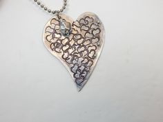 A totally unique stamped heart metal pendant. This metal heart is covered with random stamped hearts and adorned with tiny metal balls. To top it off, a metal or crystal bead is added to the top off the pendant. There are two color options - aluminum or copper. It is 24 inches long on lightweight chain. Silver Heart Necklace With Heart Beads, Metal Heart Necklace With Heart Beads, Metal Heart Necklace With Open Heart Shape, Metal Heart Necklace With Open Heart And Heart Beads, Metal Open Heart Necklace With Heart Beads, Heart-shaped Metal Necklace With Soldered Details, Silver Heart Bead Pendant Necklace, Silver Double Heart Necklace With Heart Beads, Silver Heart Pendant Necklace With Heart Beads