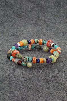 This beaded turquoise, coral, lapis, amber, spiny oyster, mother of pearl, abalone, jasper, onyx and amethyst stretchy wrap bracelet was expertly crafted by Navajo artisan Helen Tsosie.Circumference: 5 1/2" (adjustable)Width: 1/2"Free shipping on all orders! We ship with USPS and always include tracking. All orders ship within a day of payment.Returns are accepted up to 30 days after you receive your order. Just send us a message. Our shop offers cash back or store credit. The item must be returned in new condition. Southwestern Natural Stones Beaded Bracelet Gift, Artisan Beaded Multicolor Wrap Bracelet, Artisan Multicolor Beaded Wrap Bracelet, Adjustable Multicolor Artisan Wrap Bracelet, Unique Multicolor Wrap Bracelet For Healing, Multicolor Hand Wrapped Round Bead Jewelry, Multicolor Hand-strung Spiritual Wrap Bracelet, Multicolor Hand-wrapped Round Bead Jewelry, Hippie Multicolor Jewelry With Natural Stones