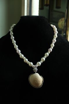 Embrace the summer sun in true style with the Mystic Tides Pendant Necklace! This beauty comes in a pristine white color that instantly lends your look luxury and an ethereal vibe, featuring alternate big and small faux pearls that are complemented with a sphere charm to truly form a look of whimsy and wonder. Rhinestone embellished seashell is sure to brighten up your sunny days. Pair with strapless dresses! Screw Barrel Clasp Closure Material: Faux Pearl Beads, Real Seashell, Elastic String Seashell Pendants, Strapless Dresses, The Mystic, Summer Sun, Pearl Beads, Sunny Days, Faux Pearl, White Color, Sea Shells