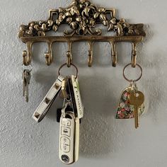 several keys hang on a wall with a key holder