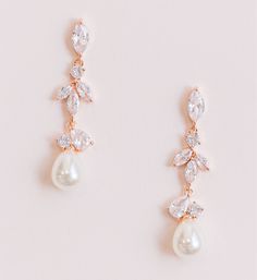 Luminous pearl drop wedding earrings designed with cascading crystals and a teardrop pearl. Cubic zirconia crystals Available in rose gold and silver Length: 1.5" FAQ: How long does it take for my order to be shipped and when will it arrive? It usually takes 2-3 business days for your order to be processed and shipped. Please email us directly or by using the contact form if you need your order rushed. Priority shipping does not rush processing and shipping times, only the time it takes for your Beach Wedding Earrings Brides, Rose Gold Cubic Zirconia Dangle Pearl Earrings, Rose Gold Teardrop Pearl Earrings For Wedding, Rose Gold Bridal Drop Earrings With Pearl, Rose Gold Drop Earrings With Pearl Detail For Bridal, Bride Earrings Gold, Beach Wedding Earrings, Wedding Earrings Bride, Wedding Earrings Silver