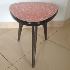 a red and black table sitting on top of a tiled floor