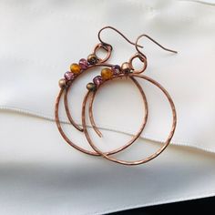 These gorgeous boho earrings are handcrafted from copper wire and glass beads. They would make the perfect gift or accent to any outfit! Earring Tutorials Free, Bohemian Rose Gold Dangle Jewelry, Bronze Wire Wrapped Earrings With Czech Glass, Bronze Wire Wrapped Czech Glass Earrings, Wire Wrapped Copper Hoop Earrings, Handmade Copper Wire Drop Earrings, Handmade Copper Wire Wrap Drop Earrings, Copper Wire Wrapped Round Hoop Earrings, Artisan Copper Wire Drop Earrings