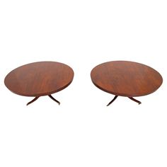 two round wooden tables with metal legs on each side, one is turned upside down