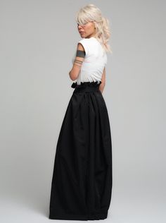 Make a bold statement with our high-waist skirt, the epitome of tailored elegance. This skirt is fashioned from premium polyester, delivering a smooth finish with a substantial feel that gracefully flows with every step. The design is accentuated by a tasteful belt that cinches the waist, while the elasticated back ensures a snug and comfortable fit. Its voluminous silhouette and sleek lines make it a versatile piece for both office wear and evening affairs. FEATURES:Includes a chic belt, elasticated back for comfort, and a high-waist cut 100% Handmade. SIZE & FIT: Fit: A relaxed fit with room to moveModel is wearing size Small or S/M View our SIZE CHART before ordering MATERIALS & CARE: Content: Polyester Care: Dry cleaning only SHIPPING: Made to order, processing time is 15 working days Chic Satin Maxi Skirt For Work, Black Relaxed Draped Skirt For Formal Occasions, Black Formal Relaxed Draped Skirt, Formal Black Relaxed Draped Skirt, Black Draped Midi Skirt For Evening, Chic Black Draped Skirt For Workwear, Modern Midi Skirt For Evening, Satin Maxi Skirt For Workwear, Chic Evening Wrap Skirt