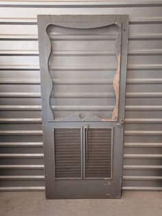 an old metal door with shutters in front of a wall