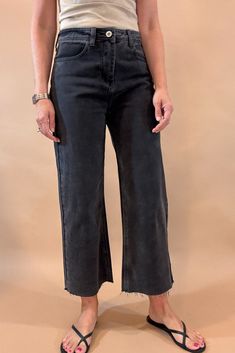 Get ready to rock the edgy chic look with these Black Crop Wide Leg Jeans. With a 23 1/2 inch seam, raw hem, slight (very slight) stretch, and distressed details, they exude effortless coolness. The lightweight denim is tapered in the back for the perfect fit, while maintaining the relaxed wide leg style. Dare to be different! Fit is true to size, Amber is modeling size small. She is 5’6”. Imported Cotton blend. Dark Wash Stretch Cropped Jeans With Frayed Hem, Trendy Distressed Bottoms For Everyday, Fall Dark Wash Bottoms With Frayed Hem, Stretch Cropped Jeans With Frayed Hem In Dark Wash, Frayed Hem Bottoms For Fall, Black Cropped Jeans For Work, Black Cotton Flare Jeans With Standard Cut, Everyday Frayed Hem Bottoms For Fall, Everyday Bottoms With Frayed Hem For Fall