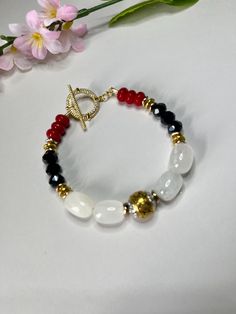 Two colors are stunning, but three--Oh my God! This handmade Color Symphony Bracelet weaves together the bold elegance of black, white, and red, adding a vibrant touch to your day. Each bead and gemstone tells its own story, coming together in perfect harmony to create a piece that truly speaks to your style. Let your accessories speak volumes and make a statement with every wear! Size 7 Elegant Crystal Bracelet With Colorful Beads For Healing, Elegant Beaded Bracelets For Healing With Colorful Beads, Elegant Rondelle Beaded Bracelets, Elegant Rondelle Beaded Bracelets With Colorful Beads, Elegant Multicolor Faceted Beads Crystal Bracelet, Elegant Multicolor Crystal Bracelet With Faceted Beads, Faceted Oval Beads Bracelets As Gift, Oval Faceted Beads Bracelets As Gift, Arm Band