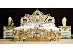 an ornate gold and white bed in a room with two vases on the floor