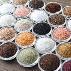 many different types of spices are in small glass bowls on the table, and there is no image here to provide a caption for