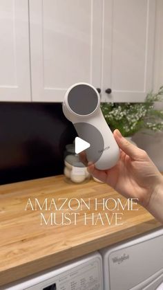 a person holding an item in their hand near a washer and dryer with the words amazon home must have on it