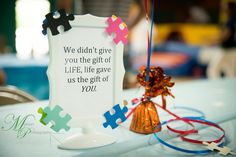 a table topped with puzzle pieces and a sign that says we didn't give you the gift of life