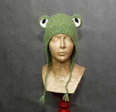 a mannequin head wearing a green knitted hat with eyes on it's face