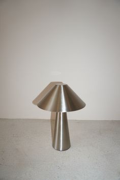 a silver lamp sitting on top of a white floor