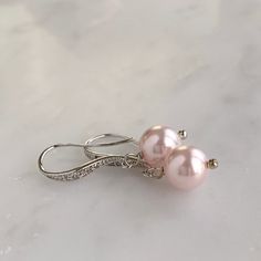 "- Silver, gold or rose gold - Choose your own Swarovski pearl color - 1\" length - .25\" width - Pearl measures 8mm - Comes in signature gift box - Easy returns If you are looking for a simple and classic pair of pearl earrings, these are perfect! The tiny Swarovski crystals in the ear wires offer a subtle shimmer to a timeless pearl drop style. Shop the whole collection: https://www.etsy.com/shop/TigerlillyCouture >> Join our mailing list << http://eepurl.com/cXRBGD" Pearl Drop Bridal Earrings, Drop Bridal Earrings, Pearl Drop Earrings Bridal, Rose Gold Bridal Earrings, Bridal Jewelry Necklace, Pearl Bridal Jewelry, Solid Gold Jewelry, Swarovski Pearls, Rose Earrings