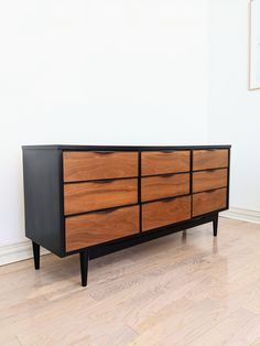 a large wooden dresser sitting on top of a hard wood floor next to a white wall