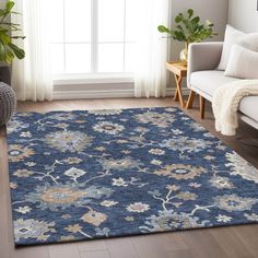 a living room with a couch, chair and rug on the floor in front of a window